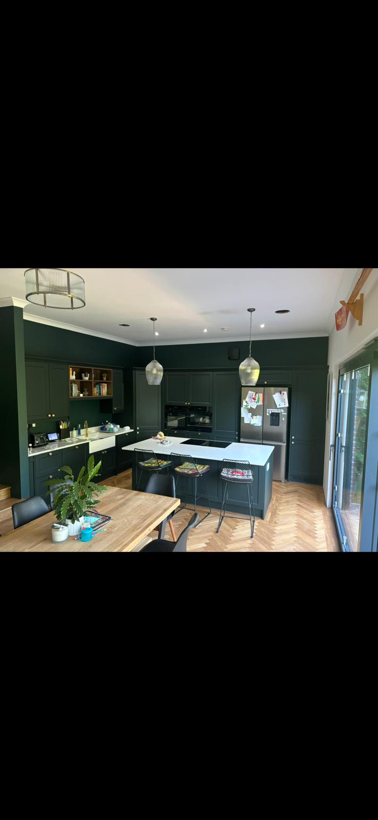 Deep green shaker kitchen with marble island and herringbone floor